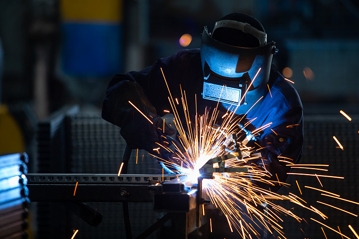 Workers wearing industrial uniforms and Welded Iron Mask at Steel welding plants
