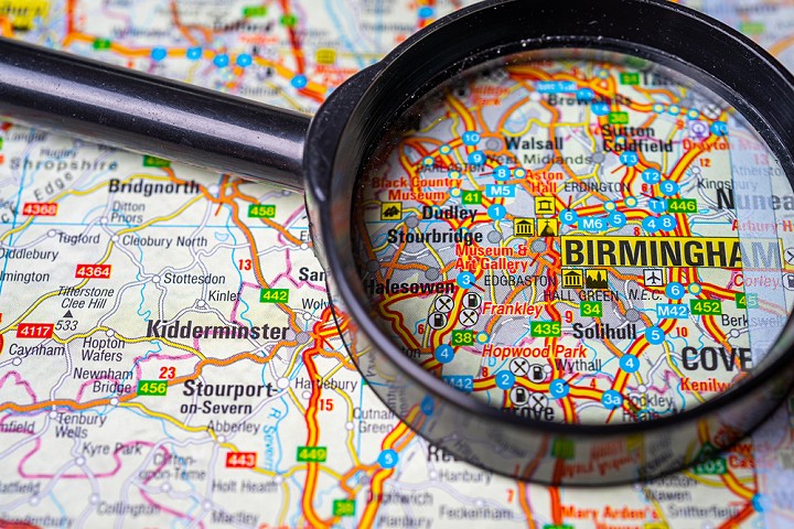a magnifying glass over the city of Birmingham on a map